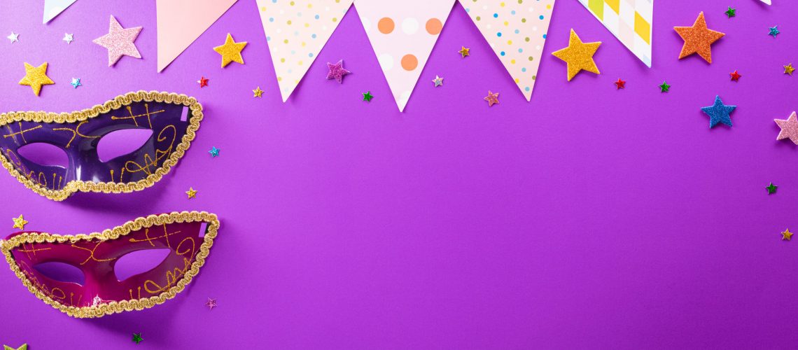 Happy Purim carnival decoration concept made from mask and sparkle star on purple background. (Happy Purim in Hebrew, jewish holiday celebrate)
